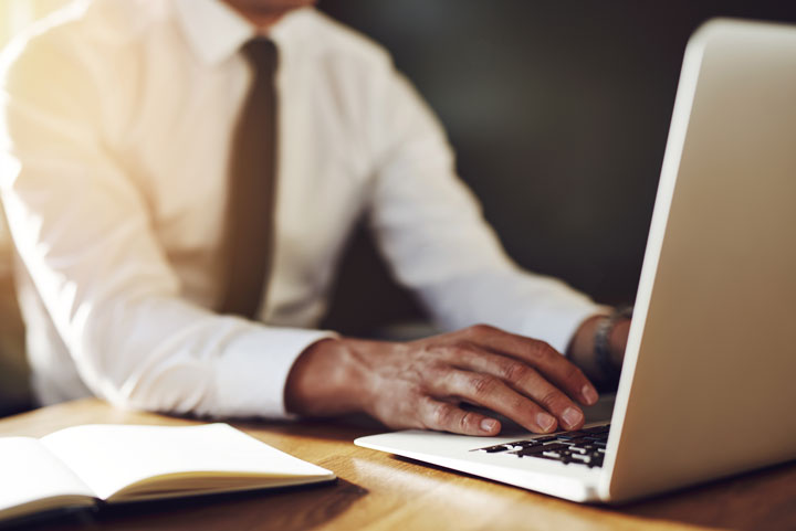 close-up-of-hands-writing-at-laptop-business-PBBSAJH