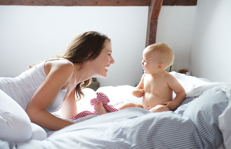 mother-and-baby-playing-on-bed-PVQ7BYS