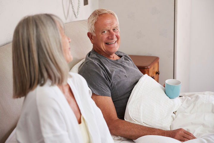 retired-couple-wearing-pajamas-sitting-in-bed