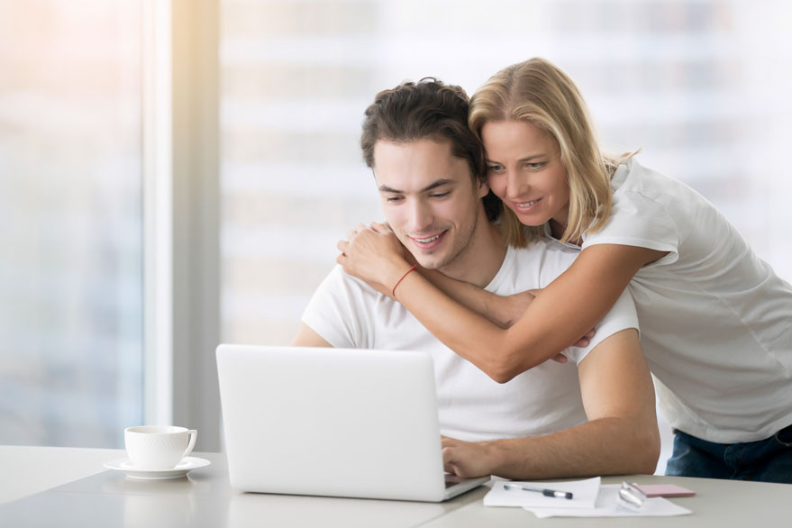 young-happy-couple-with-laptop-PBUA6YS